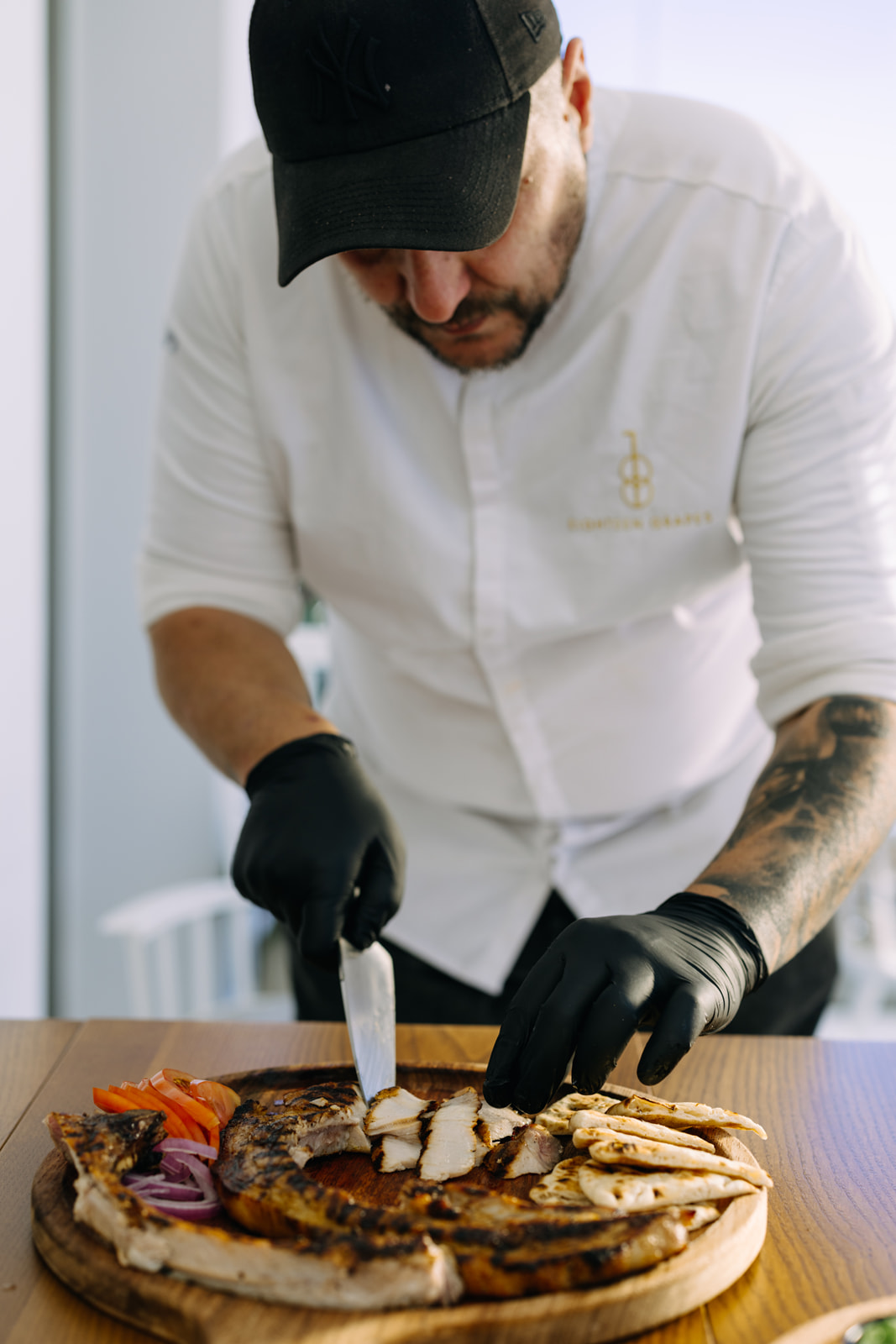 Chef's hands carefully plating a modern Greek dish with precision