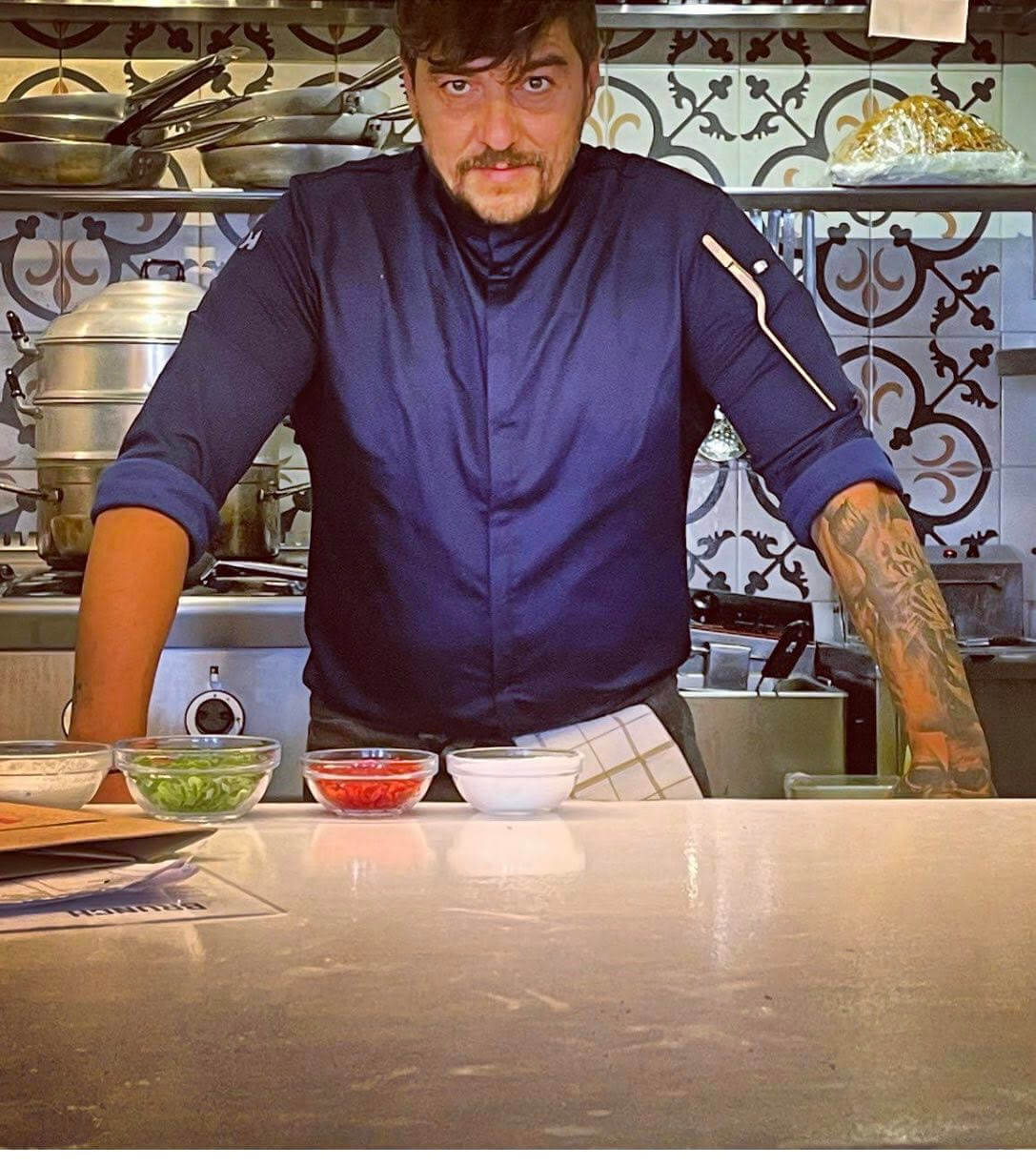 Head Chef of Tanines Restaurant preparing a signature dish in the kitchen